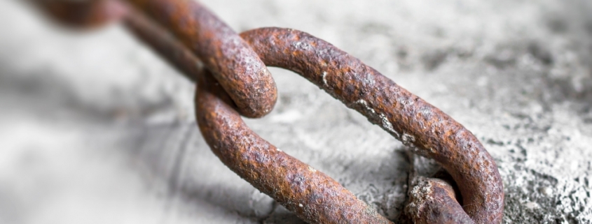 Rusty chain into the concrete