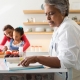 Senior woman looking at recipe book in kitchen